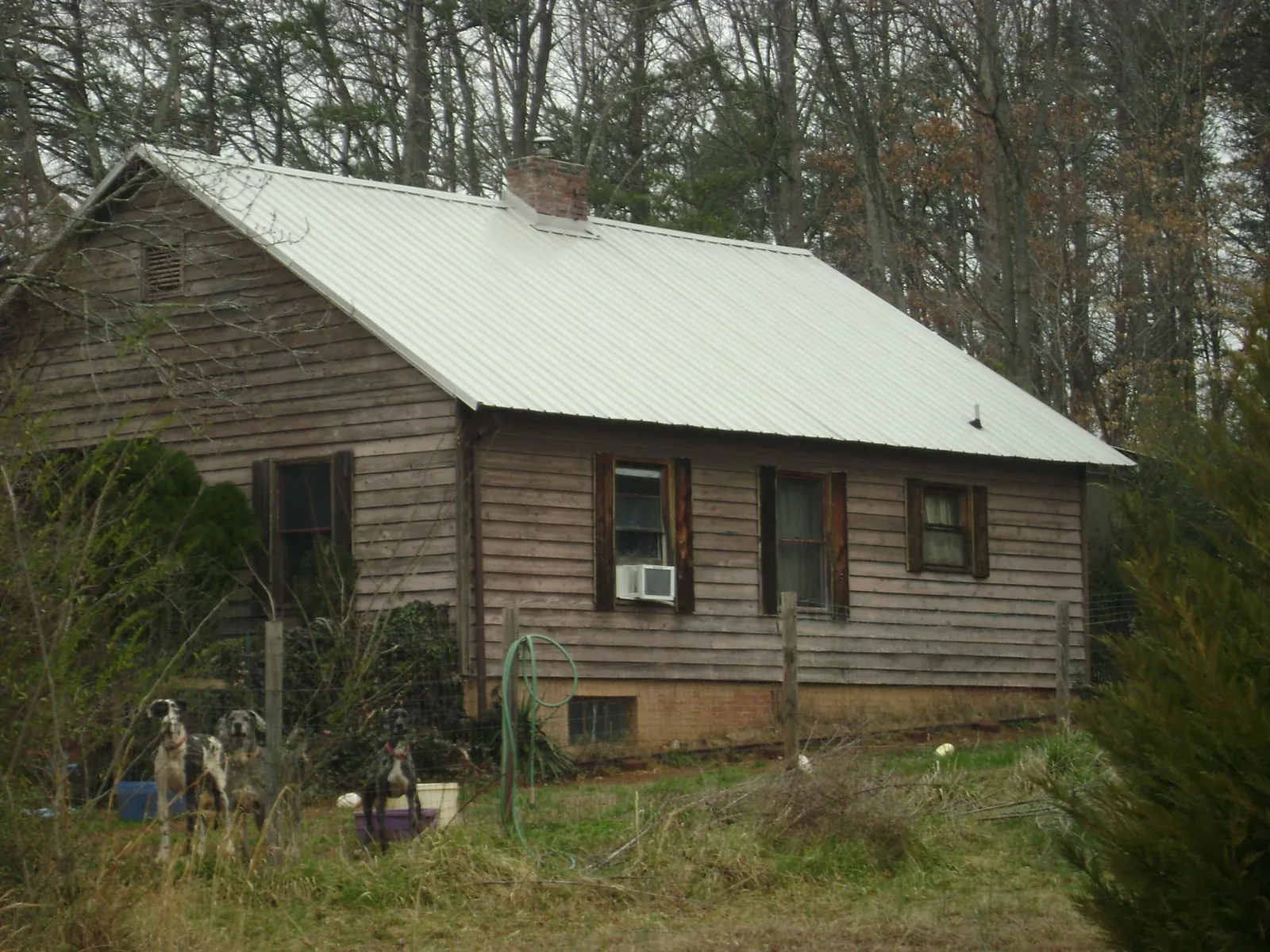 White metal roof on an old wood sided farmhouse, from a Metal Roof Installation job in Foster
